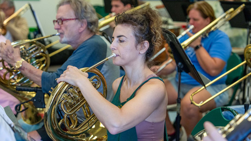 female french horn player rehearsing
